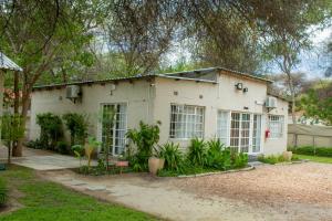 a white house with a lot of windows at Moxwini Self Catering Apartments in Maun