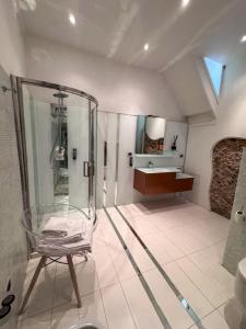 La salle de bains est pourvue d'une douche en verre et d'une chaise. dans l'établissement A' Cantunera - Apartment, à Taormine