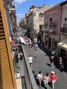 un groupe de personnes marchant dans une rue de la ville dans l'établissement A' Cantunera - Apartment, à Taormine 14 autres photos