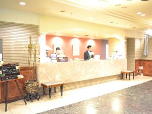 a man standing at the counter of a restaurant at Hotel Crown Hills Koriyama in Koriyama