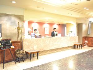 a man standing at the counter of a restaurant at Hotel Crown Hills Koriyama in Koriyama