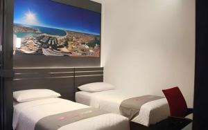 Neotel Hotel City Centre في Tanjungredep: غرفه بثلاث اسره ولوحه على الحائط +74 صورة