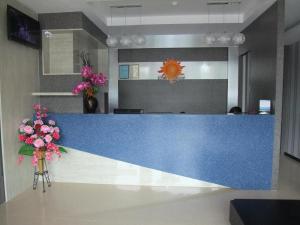 a blue counter in an office with flowers on a table at Sunshine Inn in Bintulu