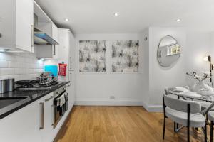 a kitchen with a table and a dining room at Stylish Roman Bath Duplex - The Bridgeton in Bath