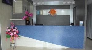 a blue counter top in a lobby with flowers at Sunshine Inn in Bintulu