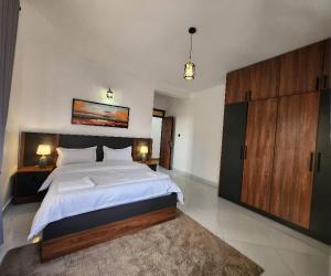 Kampala Apartments في كامبالا: غرفة نوم كبيرة مع سرير كبير وسجادة