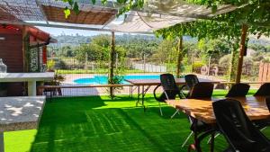a patio with tables and chairs and a swimming pool at Casa Brues in Boborás