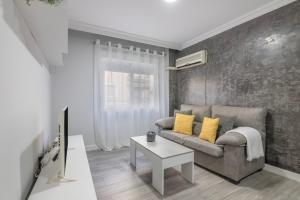 una sala de estar con un sofá y una mesa en Grey House, en Huelva