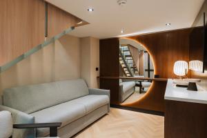 ブカレストにあるホテル トリアノンのソファと階段のあるリビングルーム