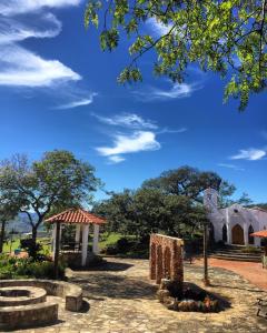 un parc avec une église et un ciel bleu dans l'établissement El Pueblito Hotel Boutique, à Samaipata