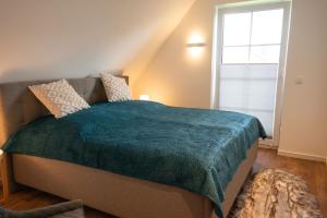 ein Schlafzimmer mit einem großen Bett und einem Fenster in der Unterkunft Haus Friesenkuss mit Hund in Wangerland