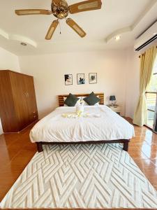a bedroom with a large bed with a ceiling fan at Sachi Home Villa Bangtao - Near Muay Thai and Beach in Ban Thalat Choeng Thale +42 photos