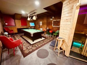 Una habitación con una mesa de billar y algunas sillas. en Premium Stay, en Bad Ems
