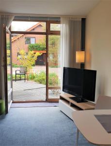 ein Wohnzimmer mit einem TV und einer Glasschiebetür in der Unterkunft home31 in Hemmingen
