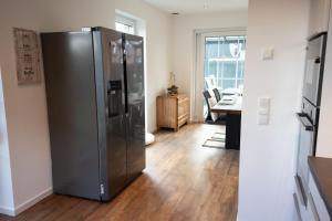 eine Küche mit einem Kühlschrank aus Edelstahl in einem Zimmer in der Unterkunft Haus Friesenkuss mit Hund in Wangerland