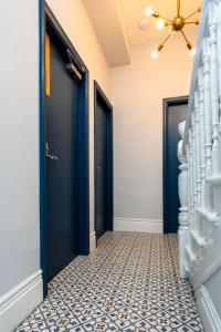 Vacant Nests The linden Hotel Seaside Resort في وايتلي باي: مدخل مع أبواب زرقاء وأرضية من البلاط