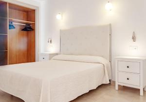 a white bedroom with two beds and two night stands at MallorcaRooms Cala Millor in Cala Millor +15 photos