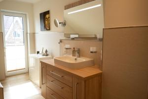 ein Badezimmer mit Waschbecken und Spiegel in der Unterkunft Haus Friesenkuss mit Hund in Wangerland + 50 Fotos