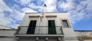 Antica Dimora Vada' في ألبيروبيلو: مبنى أبيض ذو مصاريع خضراء وشرفة