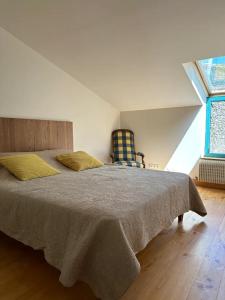 ein Schlafzimmer mit einem großen Bett und einem Stuhl in der Unterkunft Villa Harmonie in Monteton