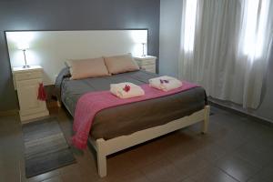 a bedroom with a bed with two pink pillows on it at San Rafael Group in San Rafael +9 photos