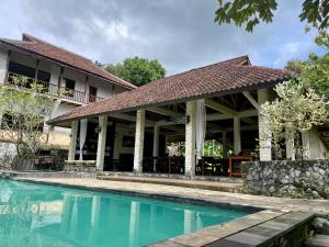 a house with a swimming pool in front of it at Covehill Green Resort in Pelabuhan Ratu