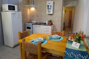 a kitchen with a wooden table with chairs and a kitchen with a refrigerator at San Rafael Group in San Rafael