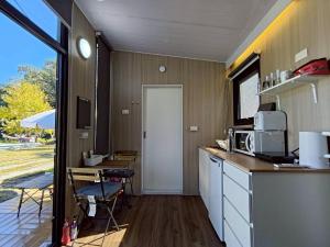 a kitchen with a counter and a table and a door at Forest Star Cottage X by Tiny Away in Hsin-ch'eng