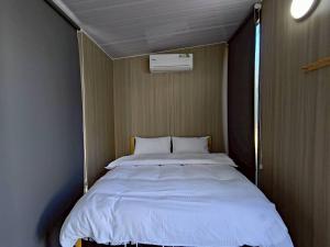 a bedroom with a large bed in the corner of the room at Forest Star Cottage X by Tiny Away in Hsin-ch'eng