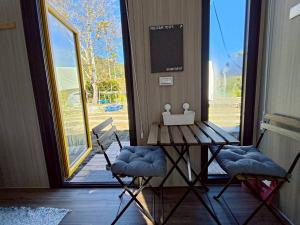 a table and two chairs in front of a door at Forest Star Cottage X by Tiny Away in Hsin-ch'eng +11 photos
