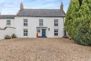 an exterior view of a white house with a driveway at 4 Bed in East Rudham oc-t28312 in East Rudham