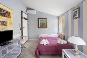 een slaapkamer met een paars bed en een televisie bij 5 Terre - Lerici - Piccolo Golfo in Lerici