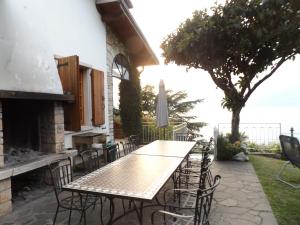 Una mesa y sillas en un patio con chimenea. en Villa Margiò, en Torri del Benaco
