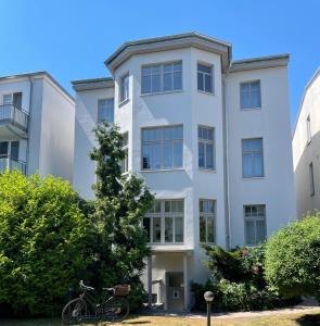 een fiets geparkeerd voor een wit gebouw bij 1 Wellenklang in Rostock