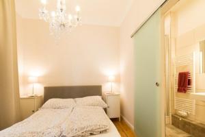 een slaapkamer met een bed en een kroonluchter bij 1 Wellenklang in Rostock