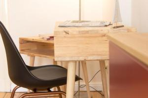 een bureau met een zwarte stoel naast een houten bureau bij 1 Wellenklang in Rostock +6 foto's