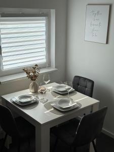 un tavolo bianco con sedie, piatti e bicchieri da vino di Ferienwohnung - An der Oder a Barbis Altre 16 foto