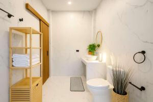 a white bathroom with a toilet and a sink at Cocolane Villa 2 in Ban Madua Wan