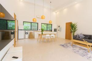 a living room with a table and a couch at Cocolane Villa 2 in Ban Madua Wan