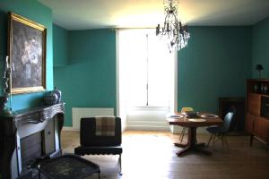 a living room with green walls and a table and a chandelier at Charming Gite In Mont Saint Vincent in Mont-Saint-Vincent