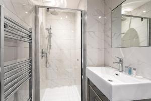 Vacant Nests The linden Hotel Seaside Resort في وايتلي باي: حمام أبيض مع حوض ودش