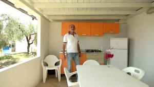マッティナータにあるLeonardo Casa Vacanzeの橙箔の台所に立つ男