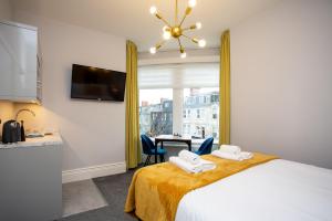 Vacant Nests The linden Hotel Seaside Resort في وايتلي باي: غرفة فندق مع سرير وطاولة