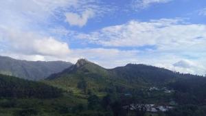 a view of a mountain range with trees and clouds at Shobha home stay in Vattavada