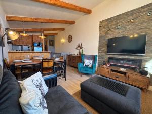 a living room with a tv and a dining room at Résidence Grand Bois A1124 Clés Blanches in La Tania