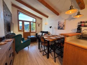 a kitchen and living room with a table and chairs at Résidence Grand Bois A1124 Clés Blanches in La Tania