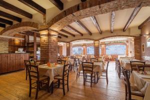 a restaurant with tables and chairs in a room at Chalet Le Alpi - Azzurro Club in Prato Nevoso