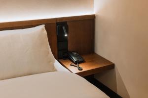 ブカレストにあるホテル トリアノンのベッド横のデスクに座る電話 +38枚の写真