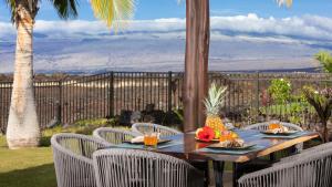 a wooden table with chairs on a patio with a view at ❤PiH❤ Starry Nights Resort Pool Waterslide Pass Bikes Beach Gear in Waikoloa