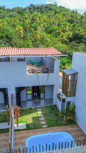a white house with a view of a yard at Pousada Mon Gâté in Japaratinga